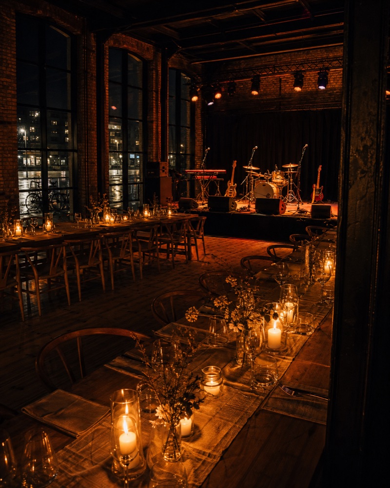 Industrielt festlokale klar til firmafest med scene og levende lys